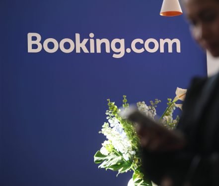 A visitor uses a smartphone at the Booking.com stand at the 2026 ITB tourism trade fair on March 04, 2026 in Berlin, Germany.