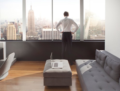 Young man looking out at city skyline.